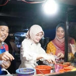 Wali Kota Kediri saat meninjau stan dan membeli kuliner yang tersedia lalu menikmatinya ditemani alunan musik. Foto: Ist