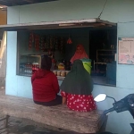 Penerima program Kurma 2022, Luluk Masruhah, saat melayani pembeli di warungnya. Foto: Ist