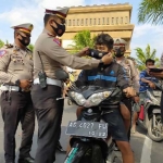 Kasatlantas Polres Kediri AKP Bobby Mochamad Zulfikar saat memakaikan masker kepada pengguna jalan yang kedapatan tidak pakai masker. (foto: ist.)