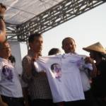 KAOS DUKUNGAN – Elemen ‘Orangnya Sutrisno Bachir’ menyerahkan kaos bergambar Jokowi warna biru kepada capres Joko Widodo (Jokowi) di tanggul lumpur titik 21 di Desa Siring Kecamatan Porong Sidoarjo, Kamis (29/5). foto : mustain/BangsaOnline