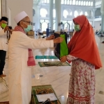  Arneta Chandra Angelina Putri, milenial yang baru masuk Islam menerima cindera mata dari KH Abdul Halim, Imam Masjid Nasional Al-Akbar Surabaya, Jumat (3/4/2020). foto: MA/ BANGSAONLINE
