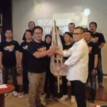 Ketua IJTI Korda Kediri periode 2024-2027, Roma Duwi Juliandi, saat menerima bendera dari Ketua IJTI Pengda Jatim, Ahmad Willyanto. Foto: Ist