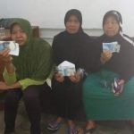 Emak-emak saat menunjukan barang bukti money politics di kantor Bawaslu Banyuwangi.