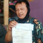 Karlin, tukang ojek online di Pacitan menunjukan bukti cek dan SIUP yang ia temukan. foto: YUNIARDI SUTONDO/ BANGSAONLINE