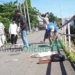 Warga saat melakukan renovasi jembatan Mrican ditahun 2011 lalu agar bisa dilalui kendaraan roda dua setelah ditutup total. foto: arif kurniawan/BANGSAONLINE