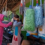 Tampak dr. Nova Rama Putra saat memasangkan masker kepada warga di lingkungan Pasar Klampis, Rabu (19/8/2020). (foto: ist).