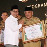 Bupati Malang Sanusi saat menerima penghargaan dari Menteri Desa PDTT Abdul Halim Iskandar.