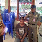 Satpol PP dan kepala Desa Nggulun melakukan pembinaan serta merapikan rambut anak punk yang tertangkap. 