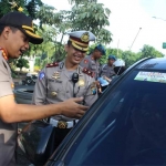 Kapolresta Sidoarjo Kombespol Zain Dwi Nugroho memasang sticker ajakan tertib berlalu lintas di mobil yang melintas.