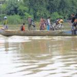 Tampak warga sedang menyeberangi Bengawan Solo dengan perahu kayu tradisional di tengah naiknya air sungai terpanjang di pulau itu. foto: EKY NURHADI/? BANGSAONLINE