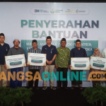 Direktur  Keuangan dan Umum Petrokimia Gresik, Robby Setiabudi Madjid, didampingi Ketua DMI Gresik, Zainal Abidin, dan SVP Sekretaris Perusahaan Petrokimia Gresik, Adityo Wibowo bersama para penerima bantuan.(foto: SYUHUD/BANGSAONLINE)