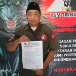 Ketua LSM Trinusa Pasuruan Raya, Erik, saat menunjukkan surat kritik terhadap berjalannya karnaval hari jadi daerah yang ke-1096.