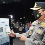 Kapolresta Sidoarjo Kombes Pol. Kusumo Wahyu Bintoro mencoba mesin scan barcode untuk memeriksa vaksin Covid-19.