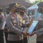 Kapolres Ngawi AKBP I Wayan Winaya menyerahkan piagam penghargaan pada pemenang lomba pengendalian dan penanganan Covid-19.