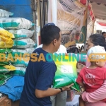 Petugas dari Perum Bulog Kancab Kediri saat melayani warga yang ingin mendapatkan beras murah. Foto: MUJI HARJITA/ BANGSAONLINE