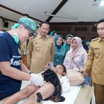Bupati Lamongan Yuhronur Efendi (dua dari kiri) saat menyaksikan pelaksanaan khitan massal di Pendopo Lokatantra, Senin (23/6/2025).