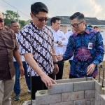  Direktur Sales & Marketing SIG, Dicky Saelan (kanan)  memperhatikan penggunaan bata interlock  presisi di perumahan Graha Asatu Puncak, Cibodas, Cianjur, Jabar. FOTO: ist.
