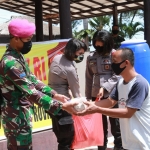 Para personel TNI-Polri saat membagikan nasi bungkus hasil sinergi Dapur Umum. 
