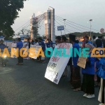 Para mahasiswa yang tergabung dalam PMII Kediri saat berorasi di pinggir jalan dan menutup sisi barat Jembatan Brantas Lama. Foto: MUJI HARJITA/BANGSAONLINE