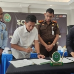 Ketua PN Bangkalan, Ernila Widikartikawati (kanan), saat menandatangani nota kesepahaman (MoU) dengan Polres Bangkalan yang diwakili kepala satuan reserse dan kriminal, AKP Bangkit Dananjaya.