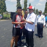 Ketua KONI Tuban Mirza Ali Manshur memberikan piala para juara. foto: SUWANDI/ BANGSAONLINE