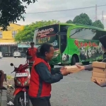 Anggota Polwan Polres Pasuruan saat membagikan nasi kotak kepada salah satu tukang ojek. 