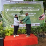 Communications & Media Relations Coordinator ExxonMobil Cepu Limited, Feni K. Indiharti, saat menyerahkan pohon secara simbolis kepada pegiat peduli lingkungan.