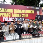 Kapolres Gresik AKBP Wahyu Sri Bintoro bersam jajaran Forkopimda dan tomas saat pemusnahan BB miras. foto: SYUHUD A/BANGSAONLINE
