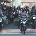 Babinsa dan Bhabinkamtibmas secara serempak mengendarai sepeda motor dengan membawa paket-paket sembako.