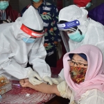 Tim kesehatan saat melakukan tindakan penanganan pencegahan Covid-19 kepada pasien. (foto: ist).