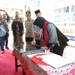 Disaksikan Bupati Lombok Timur Sukiman Azmy, Wali Kota Risma menandatangani prasasti peresmian sekolah SDN 1 Obel-obel. Foto: YUDI ARIANTO/BANGSAONLINE