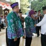 SIMBOLIS: Bupati H Saiful Ilah memasangkan baju batik kepada Jemaah Calon Haji (JCH) Sidoarjo, di Pendopo Delta Wibawa, Sabtu (20/8). foto: MUSTAIN/ BANGSAONLINE.com
