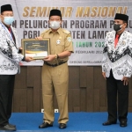 Bupati Fadeli didampingi Ketua PGRI Lamongan Adi Suwito menyerahkan penghargaan. (foto: ist)