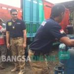 Petugas kepolisian dari Polres Kediri Kota saat mengangkut tabung gas elpiji untuk diamankan. foto: arif kurniawan/ BANGSAONLINE