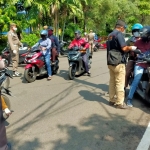 Petugas saat menggelar razia physical distancing di Jalan Pahlawan, tepatnya di depan kantor DPMPTSP Sidoarjo.