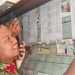 Tampak Kabid Bina Pemerintahan Desa Kabupaten Situbondo Yogi Kripsiansyah saat akan menempel hasil tes ke papan pengumuman di Pemkab Situbondo. foto: MURSIDI/ BANGSAONLINE