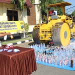 Kendaraan berat saat melindas barang bukti berupa miras hasil operasi pekat.
