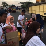 Ketua BMI Gresik Chessy Bima saat membagikan takjil. foto: SYUHUD/ BANGSAONLINE