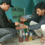 Pemuda Karang Taruna Kelurahan Tambaan saat menunjukkan BBM yang dihasilkan dari pengolahan sampah plastik.