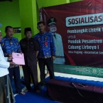Asisten Administrasi Perekonomian dan Pembangunan Setdakab Kediri, Sujud Winarko, saat menyerahkan secara simbolis PLTS kepada pengasuh Pondok Pesantren Hidayatul Mubtadiiin Cabang Lirboyo 1, Kyai Salim. Foto: Ist