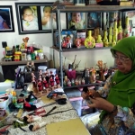 Sukma Trilaksasi saat berkarya di meja kerjanya. foto: Disna Rizki UTM/ BANGSAONLINE