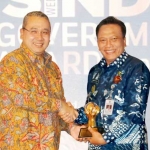 Bupati Gresik Sambari Halim Radianto menerima penghargaan Goverment Award 2017 bidang Investasi Insfrastruktur dari Menteri Desa, Pembangunan Daerah Tertinggal dan Transmigrasi, Eko Putro Sandjojo. foto: SYUHUD/ BANGSAONLINE