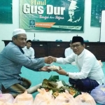 Ketua DPC PKB Ir. Mondir Rofii (kanan) memberikan potongan tumpeng kepada Ketua Dewan Syuro KH. Sayyid Umar.