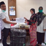 Hj. Nurul Haromain Fandi Akhmad Yani menyerahkan bantuan APD kepada Kadinkes dr. Saifudin Ghozali. foto: SYUHUD/ BANGSAONLINE