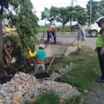 Kerja bakti bersih lingkungan yang dilakukan warga Desa Sidomojo usai pelaksanaan pilkades. Tampak Anggota Polsek Krian dan Bhabinkamtibmas menyaksikan kerja bakti yang dilakukan warga.