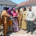 Wabup Qosim didampingi Camat Dukun Fatah Hadi, Perwakilan BPBD Diana, dan Kades Sekargadung saat menyerahkan bantuan korban kebakaran rumah. foto: SYUHUD/ BANGSAONLINE