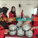 Ketua DPC PDI Perjuangan Kabupaten Kediri, Murdi Hantoro, saat ikut menata tumpeng mini yang akan dibagikan kepada warga dan Panti Asuhan (foto: Muji Harjita)