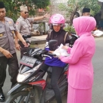 Petugas Polsek Senori bersama istri saat berbagi takjil kepada pengguna jalan. 