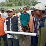 Bupati LSM FPSR Aris Gunawan bersama warga saat mendatangi tanah gendom di Desa Kedamean. foto: SYUHUD/ BANGSAONLINE