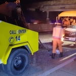 Petugas sedang mengevakuasi microbus berikut para penumpang dan sopir.